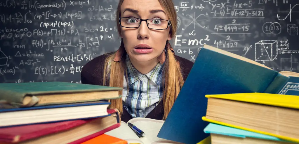 Eine Frau sitzt vor Bücher und hat Prüfungsangst