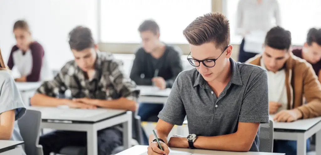 Ein junger Mann sitzt in einer Prüfung und hat Prüfungsangst